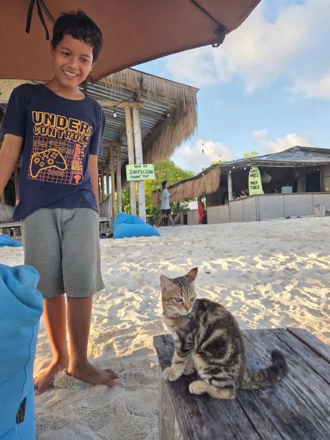 Jongetje met kat bij warung op Tanjung Aan Beach